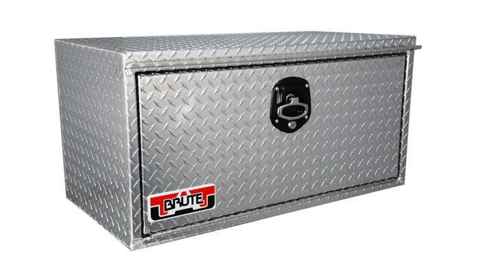 A silver aluminum underbody tool box with a diamond tread pattern and a branded lock on the front.