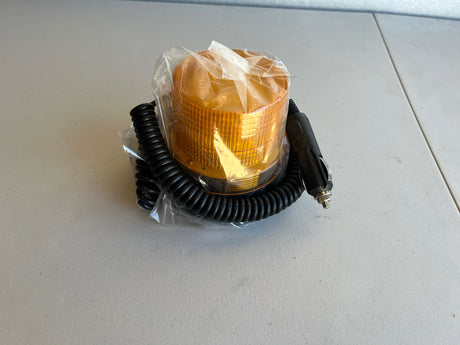 Amber warning light with black coiled cable on a white surface