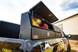 Truck bed with open Brute toolbox and tools inside, against a clear sky. Powder Coated black great for commercial trucks