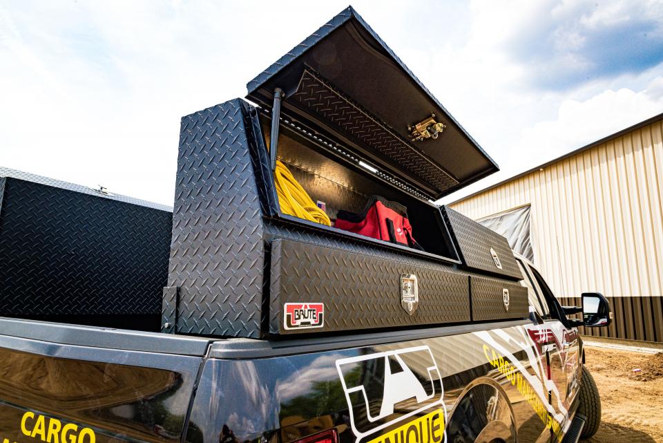 Truck bed with open Brute toolbox and tools inside, against a clear sky. Powder Coated black great for commercial trucks